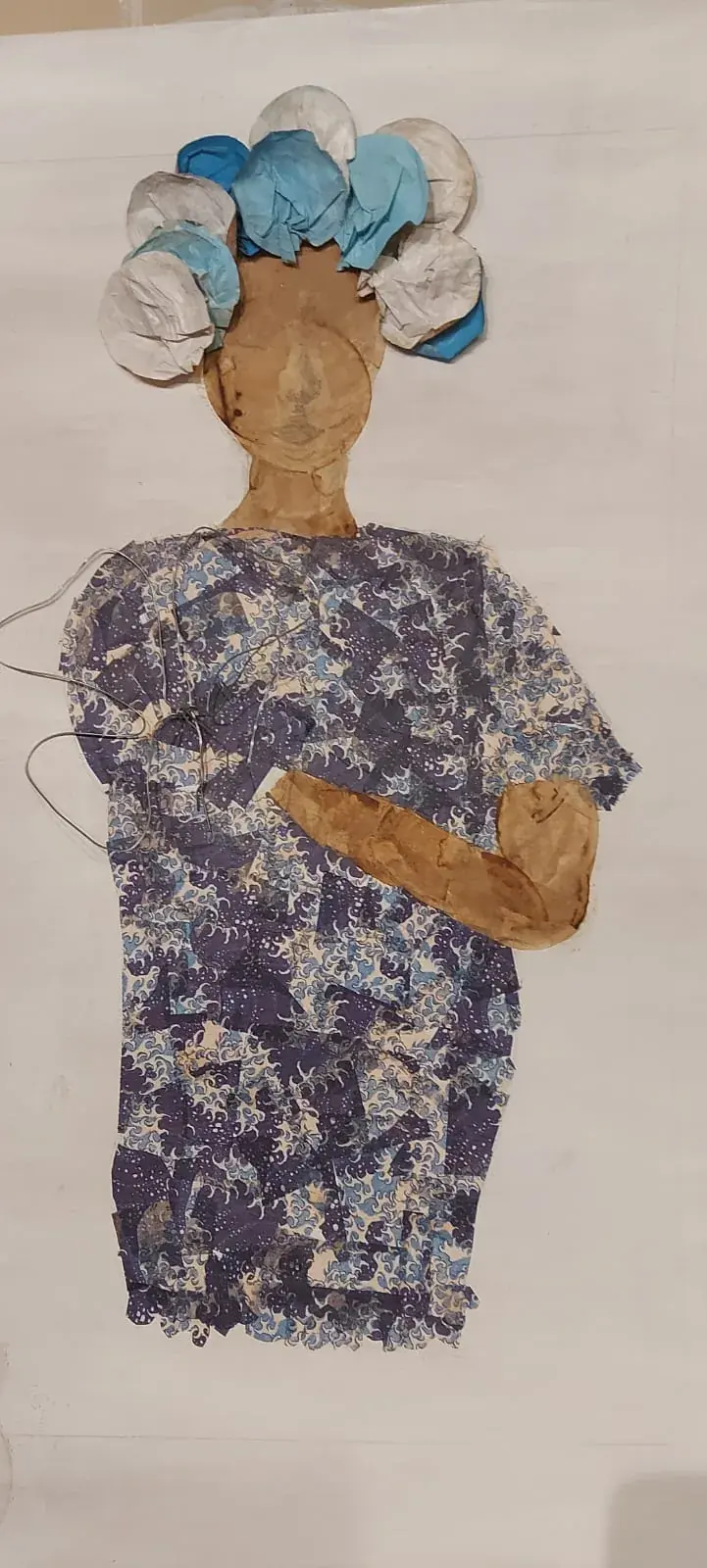 Figura de collage con vestido de papeles azules y tocado de flores — taller de Estela Pacheco